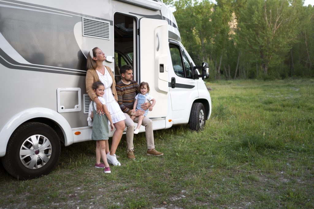 family sitting next to their van